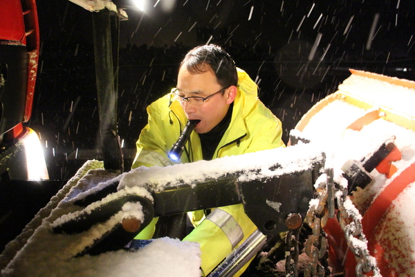 風(fēng)雪中，馬巢公司夜班除雪隊員李夫勝正在調試除雪鏟大燈.jpg